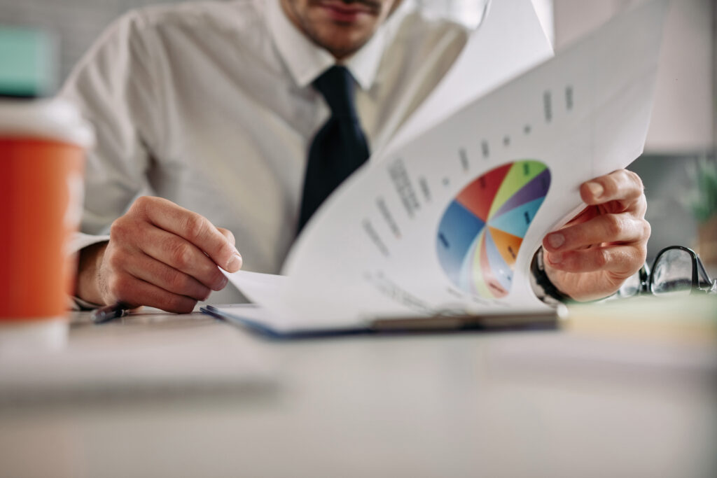 close up of businessman working on business reports at office desk.