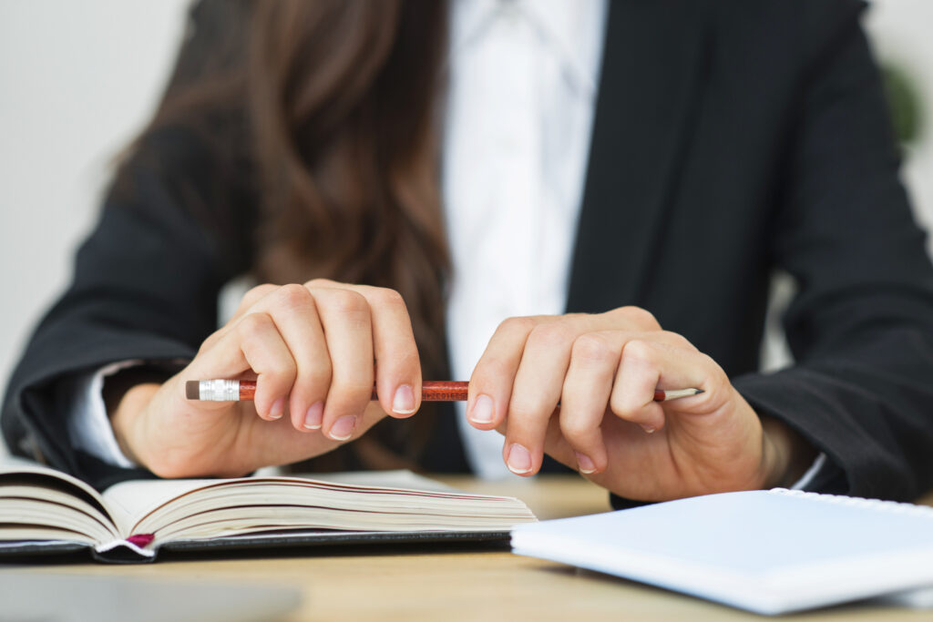 close up businesswoman holding red pencil her two hands desk